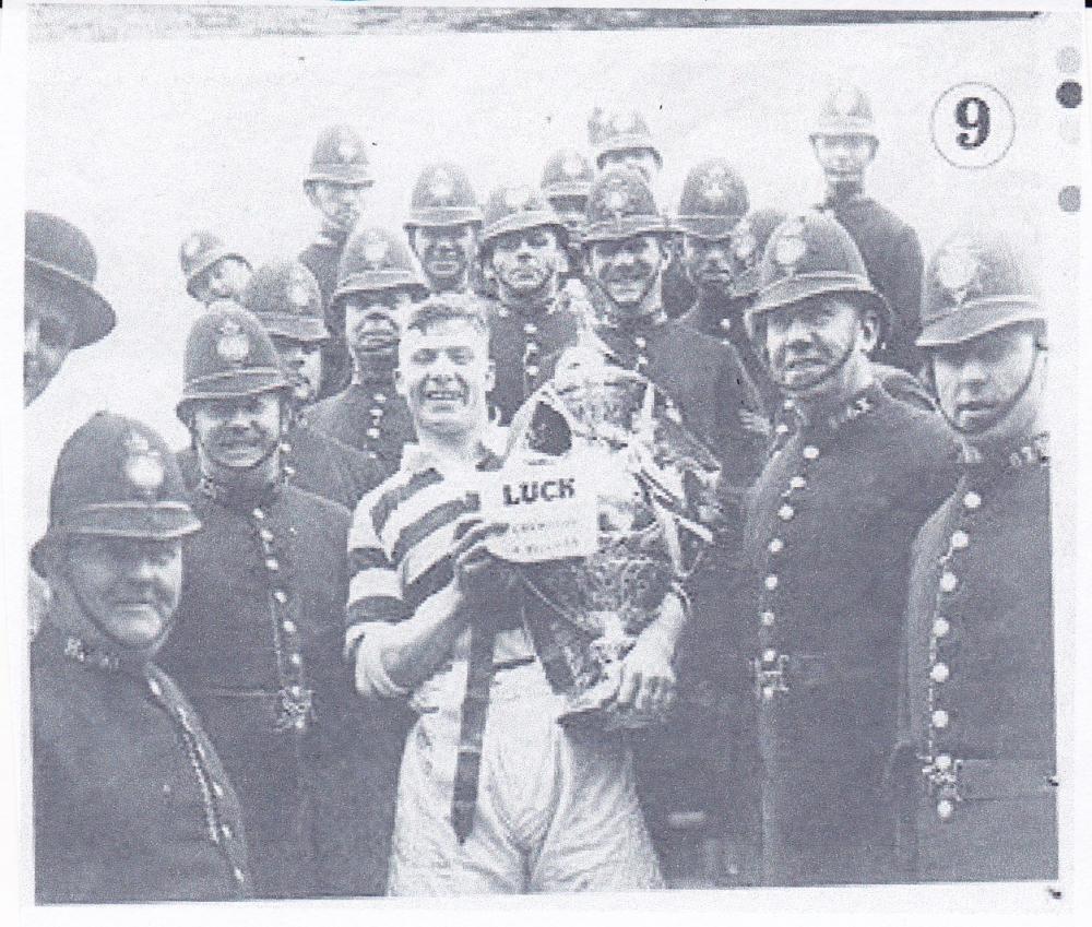Wigan Rugby League player, holding the R.L. cup, surrounded by the constabulary.