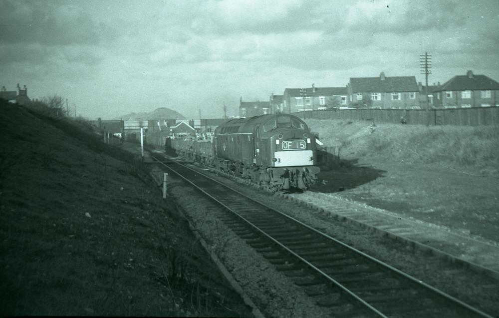 ee type 4 passing bryn with colliery remains background.