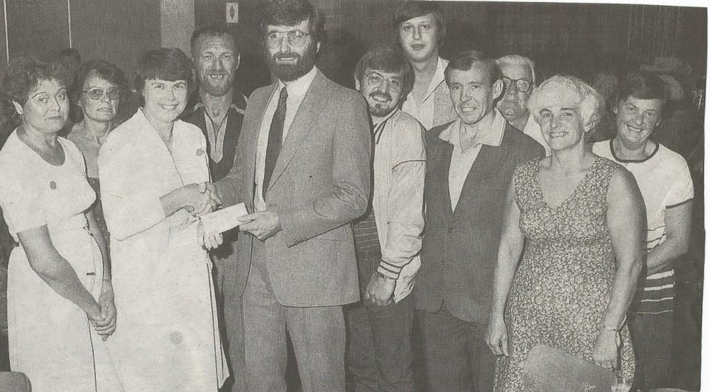 Supporters' club members hand over a cheque.