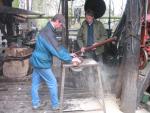 Ian Thompson and Alan Davies cutting wood for the boiler (83K)