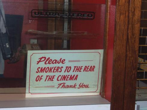 Sign reads 'Please - Smokers to the rear of the cinema'