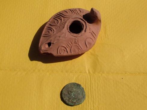 Replica pottery item and a Roman coin found in the dig